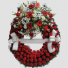 Corona funeraria con aro de claveles rojos y cabezal superior con flores blancas y rojas